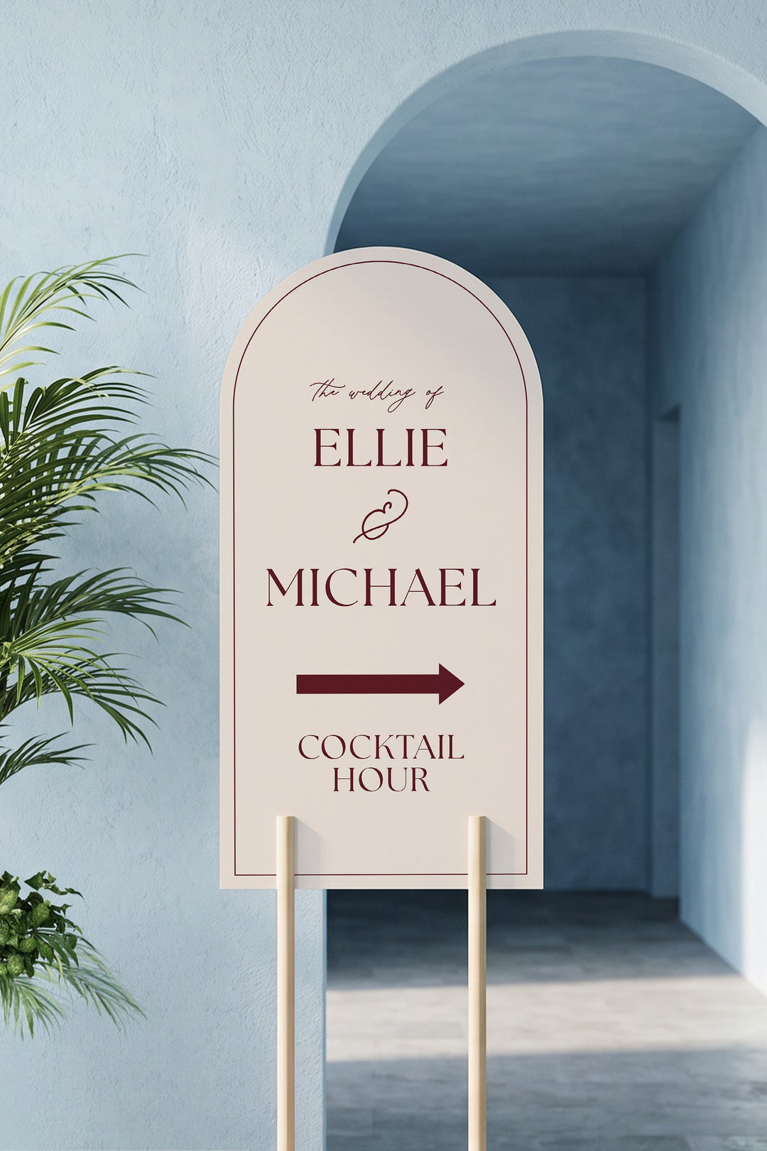 Linen off white arch cocktail hour directional sign leaning in a blue plaster archway beside a potted palm #color_Linen