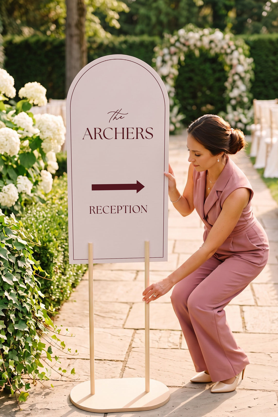 Linen off white arch reception directional sign on a garden path beside white hydrangeas #color_Linen