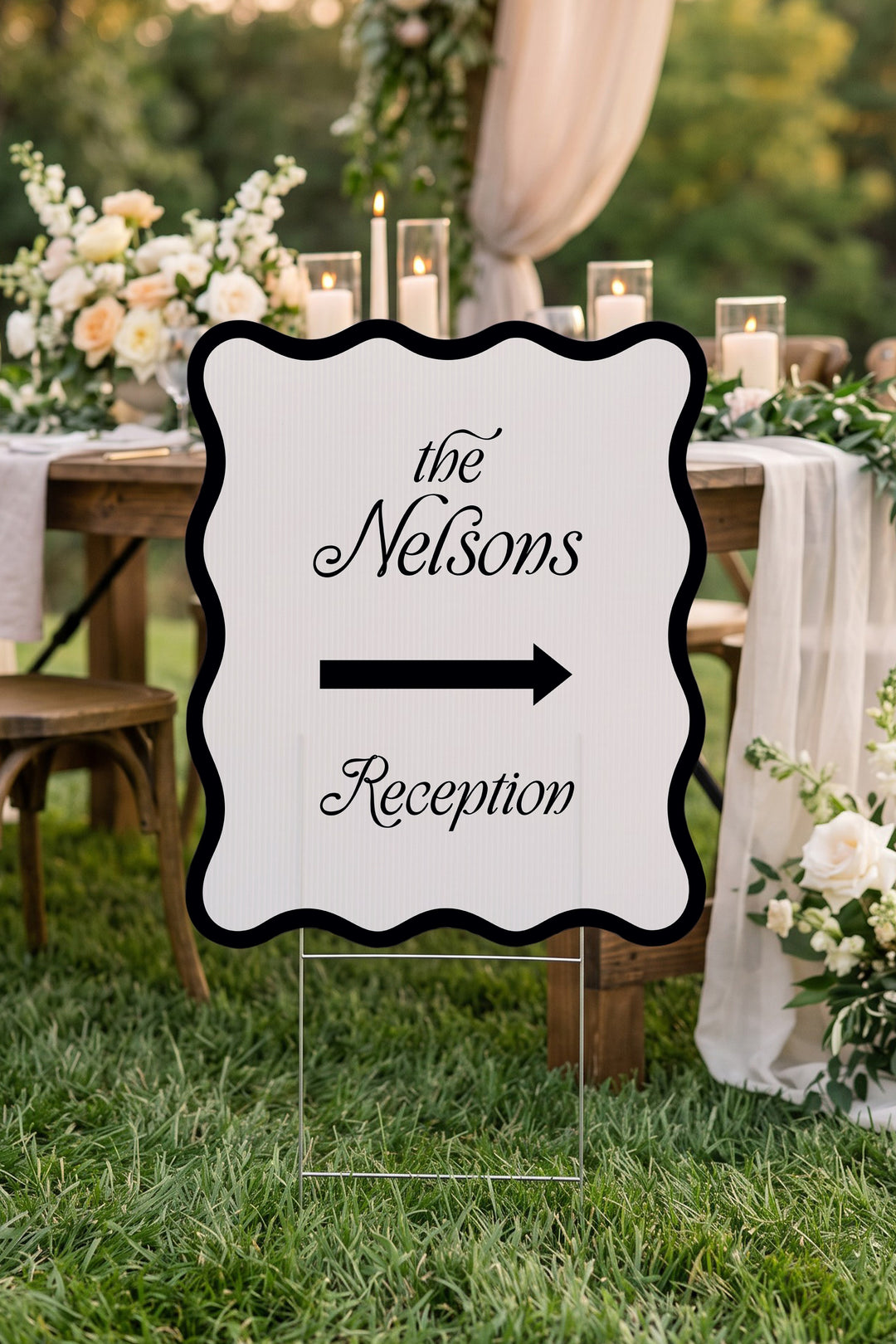 Black wavy wedding directional yard sign beside a candlelit reception table #Color_Black