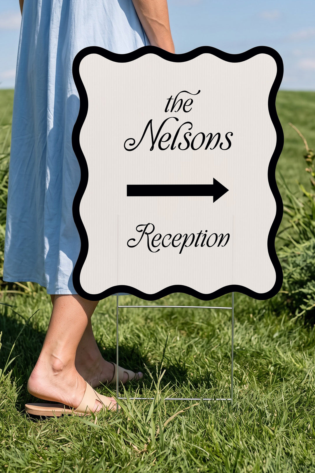Black wavy wedding directional yard sign held beside a guest for scale #Color_Black