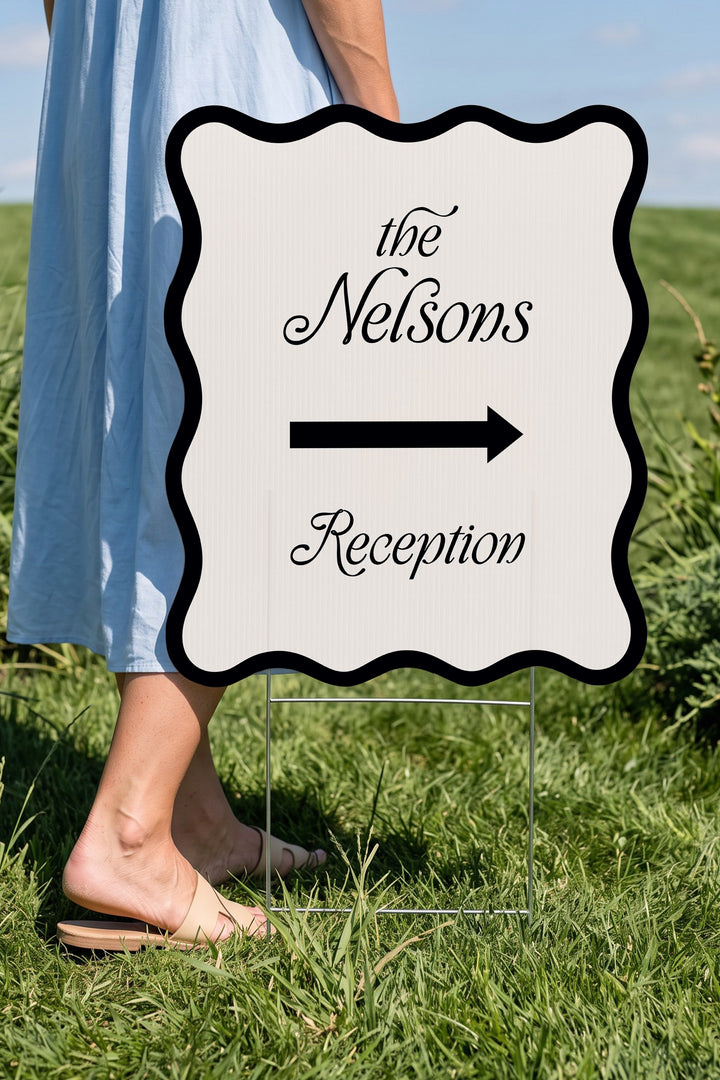 Black wavy wedding directional yard sign held beside a guest for scale #Color_Black