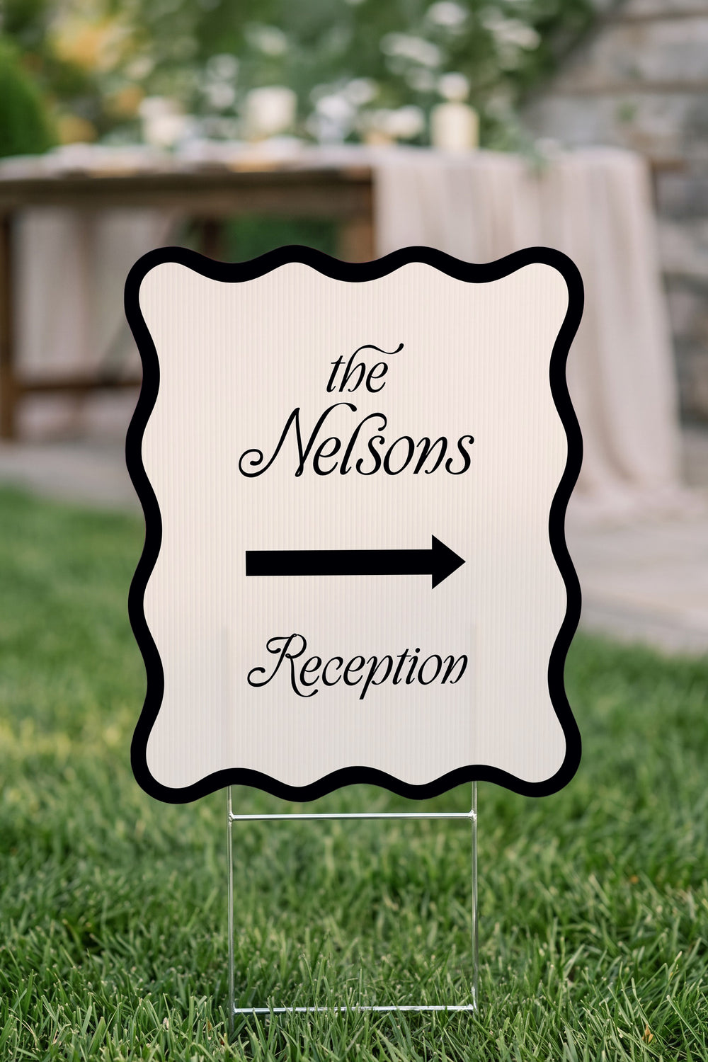 Black wavy wedding directional yard sign staked on a garden path #Color_Black