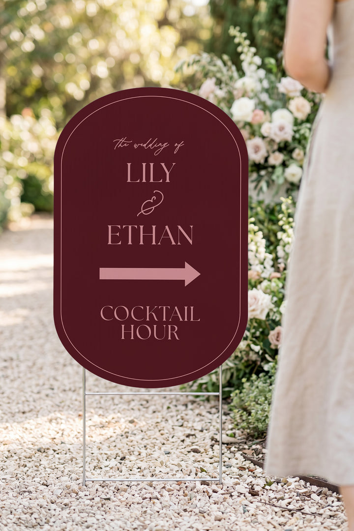 Merlot pill wedding directional yard sign in a garden beside a flower arch #Color_Merlot