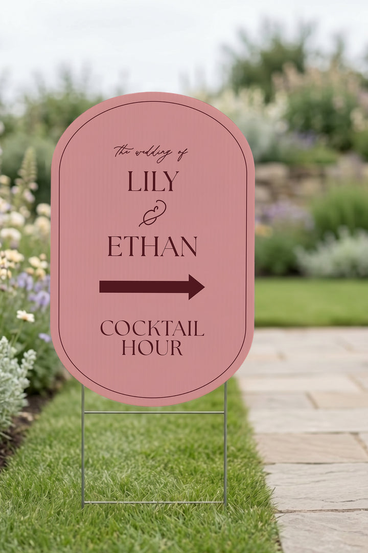 Rosé pink pill wedding directional yard sign staked in a lawn beside a stone path #Color_Rosé