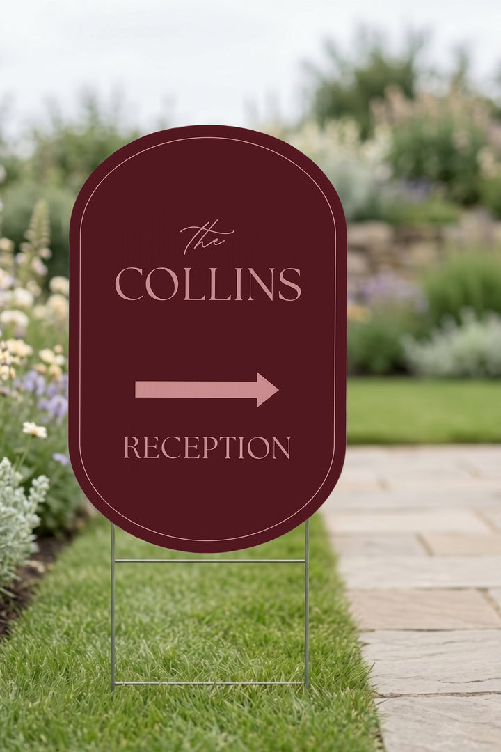 Merlot pill wedding directional yard sign staked in a lawn beside a stone path #Color_Merlot